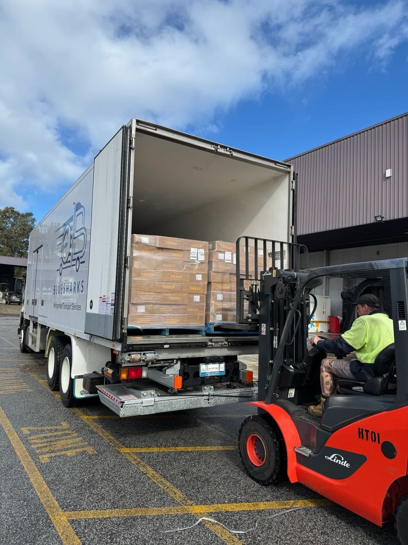 Pallets being loaded into a Bluesharks24H truck by forklift