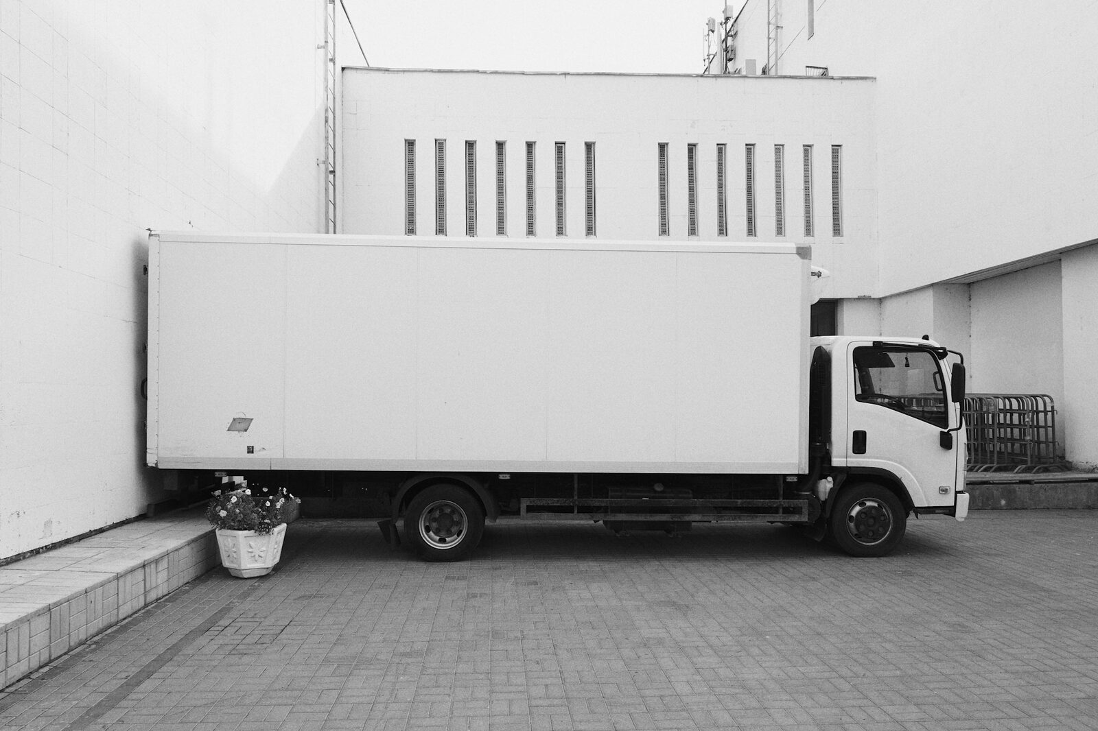Rigid refrigerated truck with a fridge unit parked at a loading area