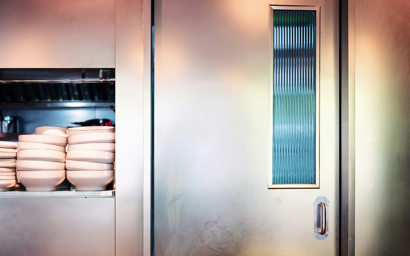 Stainless steel walk-in cool room door in a commercial kitchen